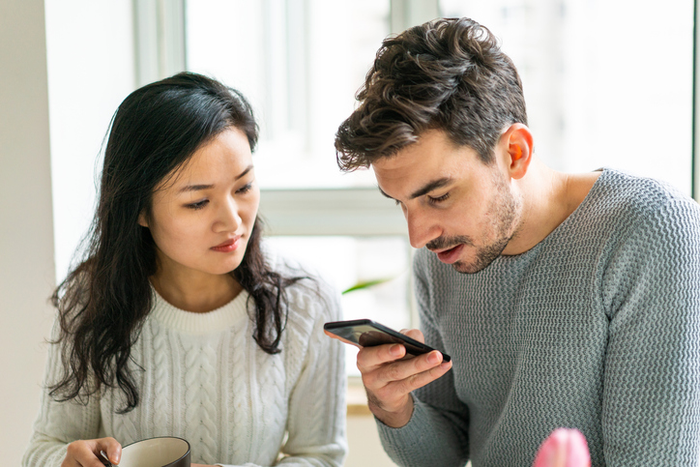 Confused couple looking at something on a smartphone