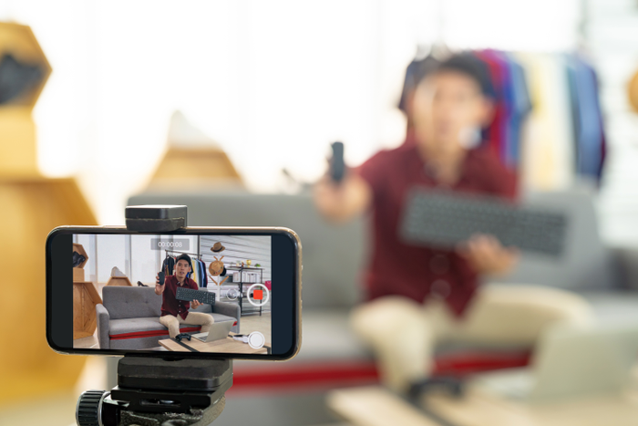 Man recording video of himself on phone on a stand